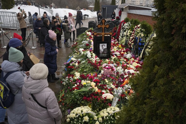 FILE - People gather to lay flowers at the grave of Alexei Navalny the day after his funeral in Moscow, on Saturday, March 2, 2024. Navalny, who was President Vladimir Putin's fiercest foe, was buried after a funeral that drew thousands of mourners amid a heavy police presence. (AP Photo, File)