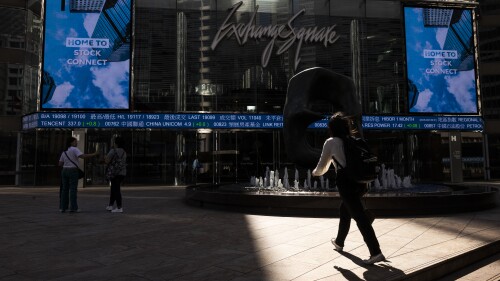 A pedestrian passes by the Hong Kong Stock Exchange electronic screen in Hong Kong, Thursday, June 29, 2023. Asian stock markets were mixed Thursday after leaders of major central banks said they need to keep interest rates high to fight persistent inflation despite fears that might tip the global economy into recession. (AP Photo/Louise Delmotte)