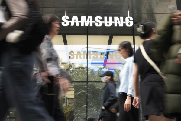 People pass by a Samsung Gangnam store in Seoul, South Korea, Tuesday, April 30, 2024. Samsung Electronics on Tuesday reported a 10-fold increase in operating profit for the last quarter as the expansion of artificial intelligence technologies drives a rebound in the markets for computer memory chips. (AP Photo/Ahn Young-joon)