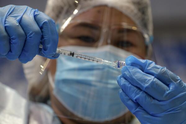 FILE - A health worker prepares to administer Russia's Sputnik V COVID-19 vaccine inside the Makati Coliseum, in Manila, Philippines on May 4, 2021. On Monday, the U.S. will implement a new air travel policy to allow in foreign citizens who have completed a course of a vaccine approved by the Food and Drug Administration or the World Health Organization. That leaves people in Mexico, Hungary, Russia and elsewhere who received the non-approved Russian Sputnik V vaccine or the China-produced CanSino vaccine ineligible to board U.S.-bound flights. (AP Photo/Aaron Favila, File)