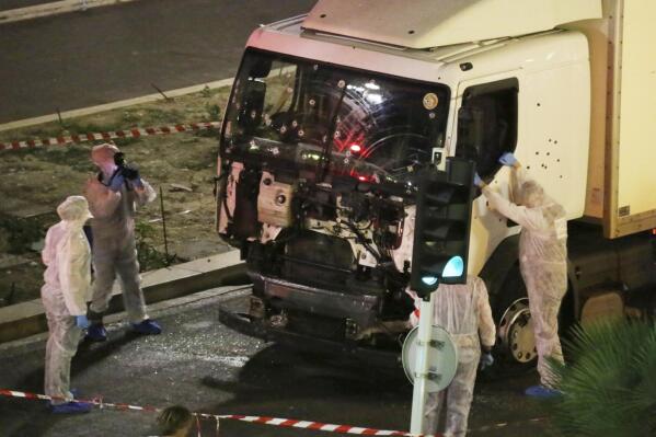 FILE - Authorities investigate a truck after it plowed through Bastille Day revelers in the French resort city of Nice, France, killing 86 people on July 14, 2016. A French court on Tuesday Dec.13, 2022 convicted eight people charged in connection with a truck attack more than six years ago by an Islamic State sympathizer that killed 86 people celebrating Bastille Day in the French Riviera city of Nice. (Sasha Goldsmith via AP, File)