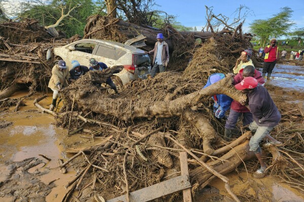CORRECTS REFERENCE FROM BURST DAM TO BLOCKED TUNNEL - People try to clear the area after a river broke through a blocked tunnel causing floodwaters in the Mai Mahiu area of Nakuru County, Kenya, Monday, April 29, 2024. (AP Photo)