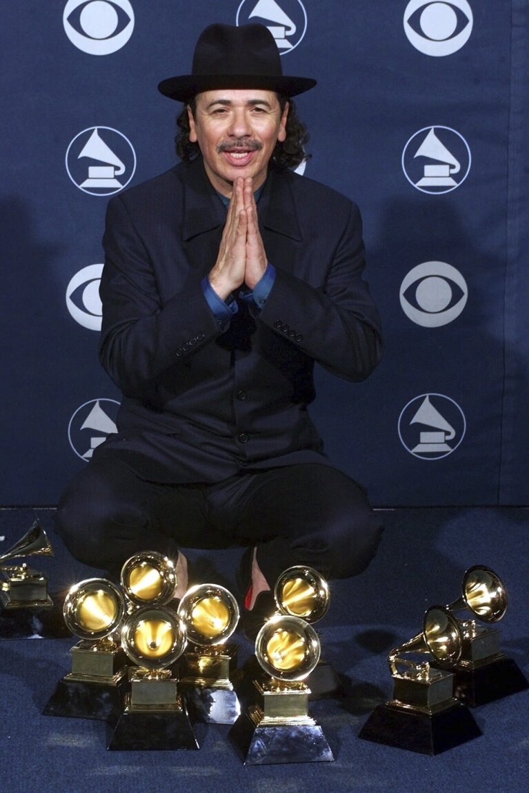 FILE - Carlos Santana poses with his eight Grammy Awards at the 42nd Grammy Awards in Los Angeles on Feb. 23, 2000. A new documentary "Carlos" covers the music career of the multi-Grammy Award-winning artist. (AP Photo/Reed Saxon, File)