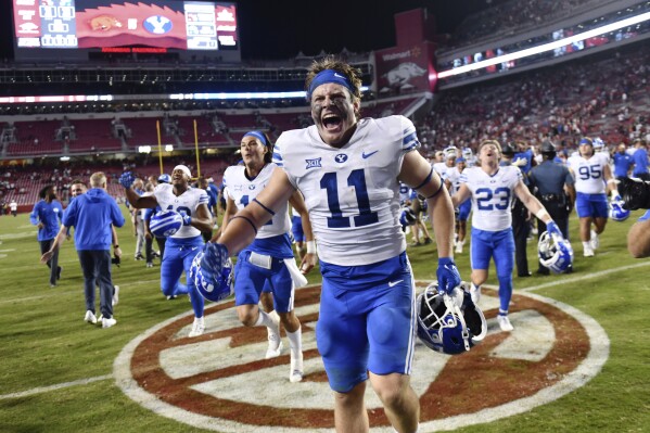 BYU linebacker Harrison Taggart (11) and teammates celebrate a win over Arkansas during an NCAA college football game Saturday, Sept. 16, 2023, in Fayetteville, Ark. (AP Photo/Michael Woods)