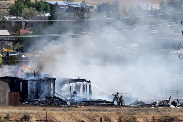 Firefighters and rescue personnel respond to a plane crash that struck a home in Santa Fe, N.M.,, Tuesday morning, July 18, 2023. (Addie Moore//The Albuquerque Journal via AP)