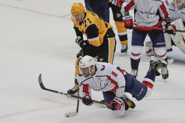 Washington Capitals' Alex Ovechkin (8) tumbles to the ice in front of Pittsburgh Penguins' Evgeni Malkin (71) after clearing the puck during the third period of an NHL hockey game, Saturday, March ...