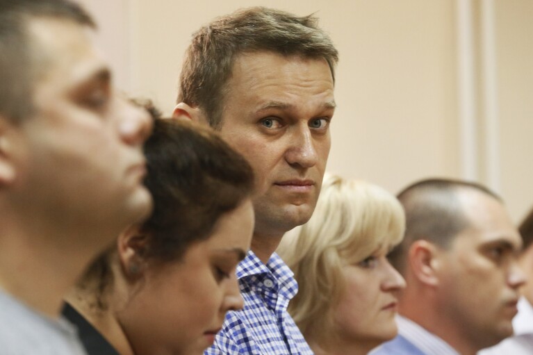 FILE - Russian opposition leader Alexei Navalny, center, and his former colleague Pyotr Ofitserov, foreground, listen to judge in a court in Kirov, Russia, on July 18, 2013. Alexei Navalny, the fiercest foe of Russian President Vladimir Putin who crusaded against official corruption and staged massive anti-Kremlin protests, died in prison Friday Feb. 16, 2024 Russia’s prison agency said. He was 47. (AP Photo/Dmitry Lovetsky, File)