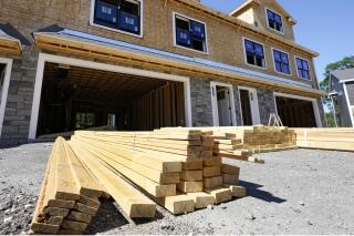 In this June 24, 2021 photo, lumber is piled at a housing construction site in Middleton, Mass.  Rising costs and shortages of building materials and labor are rippling across the homebuilding industry, which accounted for nearly 12% of all U.S. home sales in July. Construction delays are common, prompting many builders to pump the brakes on the number of new homes they put up for sale. As building a new home gets more expensive, some of those costs are passed along to buyers.  (AP Photo/Elise Amendola)