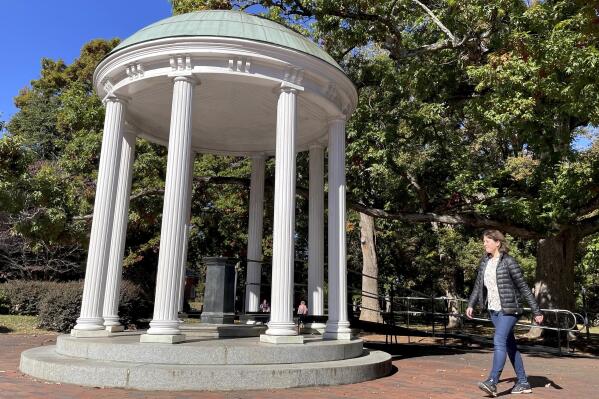 A student walks by the Old Well at the University of North Carolina at Chapel Hill, a rotunda and campus landmark at the southern end of McCorkle Place, on Monday, Oct. 24, 2022. A Confederate statue known as Silent Sam statue once stood in the plaza before it was toppled by protesters in 2018. (AP Photo/Hannah Schoenbaum)