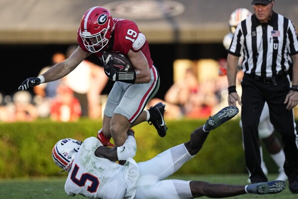 Georgia tight end Brock Bowers (19) is wrapped up by Tennessee-Martin safety Josh Hastings (5) after a catch during the first half of an NCAA college football game Saturday, Sept. 2, 2023, in Athens, Ga. (AP Photo/John Bazemore)