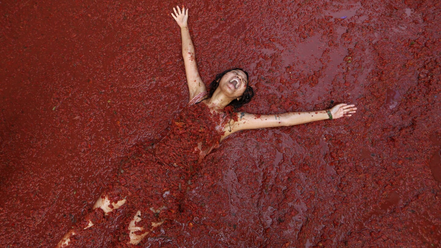 Revelers hurl tomatoes at each other and streets awash in red pulp in Spanish town's Tomatina party
