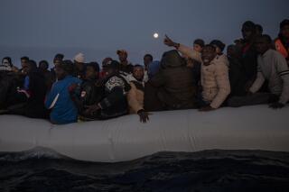 FILE - Migrants and refugees from different African nationalities react on an overcrowded wooden boat, as aid workers of the Spanish NGO Open Arms approach them in the Mediterranean Sea, international waters, off the Libyan coast, in this Friday, Jan. 10, 2020, file photo. When Libyan security forces rescued her earlier this year, a young Somali woman thought it would be the end of her suffering. For more than two years, she had been imprisoned and sexually abused by human traffickers notorious for extorting, torturing and assaulting migrants like her trying to reach Europe. Instead, the 17-year-old said, the sexual assaults against her have continued, only now by guards at the government-run center in the Libyan capital Tripoli where they are being kept. (AP Photo/Santi Palacios, File)