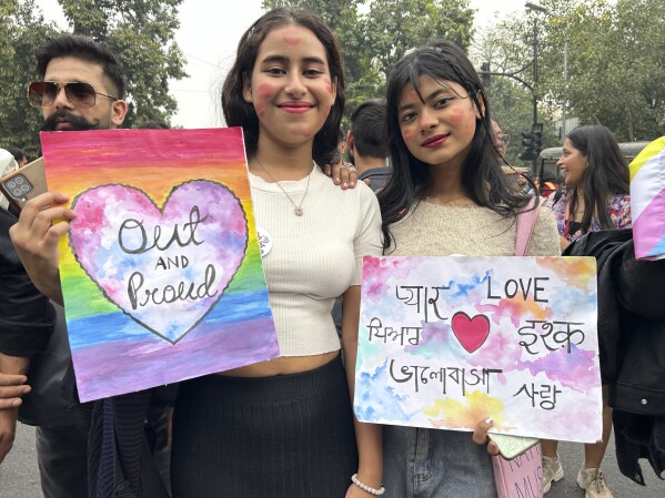 Participants of the Delhi Queer Pride Parade carrying placards saying 'Out and Proud' and 'Love' pose for a photograph during the march in New Delhi, India, Sunday, Nov. 26, 2023. This annual event comes as India's top court refused to legalize same-sex marriages in an October ruling that disappointed campaigners for LGBTQ+ rights in the world's most populous country. (AP Photo/Shonal Ganguly)