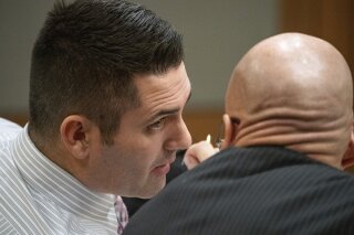 In this photo taken Tuesday, Dec. 3, 2019, dentist Seth Lookhart talks with his lawyer Paul Stockler during his trial in Anchorage, Alaska. The Alaska dentist is accused of fraud and unnecessarily sedating patients and also performing a procedure while riding a wheeled, motorized vehicle known as a hoverboard, authorities said. Prosecutors charged 34-year-old Seth Lookhart with felony Medicaid fraud and reckless endangerment. (Loren Holmes/Anchorage Daily News via AP)