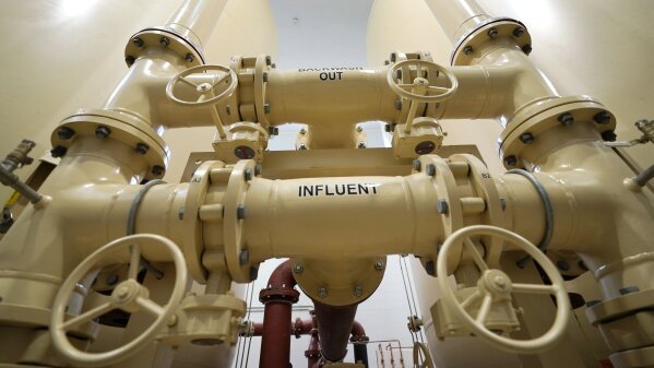 In this Friday, Aug. 14, 2020, photo valves and piping are labeled backwash out and influent in Merrimack, N.H., in an under-construction town water filtration site for two contaminated wells, which are about two miles from the Saint-Gobain plastics factory. (AP Photo/Charles Krupa)