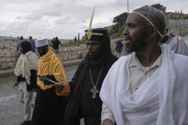 Ethiopian Orthodox Christian walk holding palm branches on the eve of Palm Sunday holiday on the Mount of Olives in Jerusalem's Old City, Sunday, April 13, 2025. (AP Photo/Mahmoud Illean)