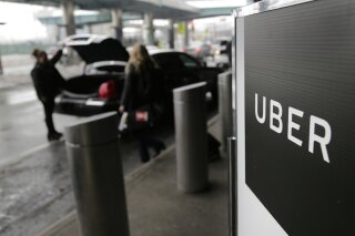 
              FILE - In this March 15, 2017, file photo, a sign marks a pick-up point for the Uber car service at LaGuardia Airport in New York. Uber is coming clean about its cover-up of a year-old hacking attack that stole personal information about more than 57 million of the beleaguered ride-hailing service's customers and drivers. The revelation Tuesday marks the latest stain on Uber's reputation. (AP Photo/Seth Wenig, File)
            