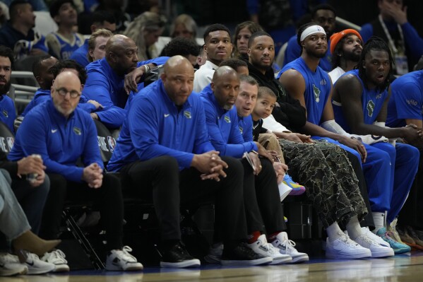 Milwaukee Bucks' Giannis Antetokounmpo and Damian Lillard watch from the bench during the first half of an NBA basketball game against the Detroit Pistons, Sunday, April 13, 2025, in Milwaukee. (AP Photo/Aaron Gash)