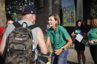 FILE - In this Aug. 12, 2021 file photo, Iowa Gov. Kim Reynolds attends the opening day of the Iowa State Fair in Des Moines, Iowa. Public health officials in Iowa's largest county are sounding alarms that too few people are wearing masks and getting vaccinated as coronavirus cases and hospitalizations climb. Officials are especially concerned in Polk County, which just hosted more than 1 million visitors to the Iowa State Fair, where mask wearing was voluntary. (Byron Houlgrave/The Des Moines Register via AP, File)