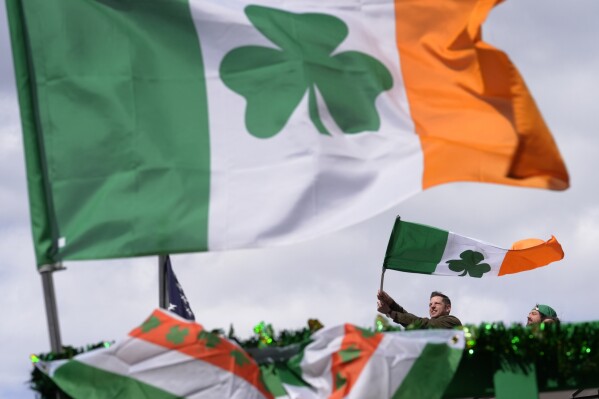 A person waves an Irish flag while watching the St. Patrick's Day parade, Sunday, March 17, 2024, in Boston's South Boston neighborhood. (AP Photo/Steven Senne)