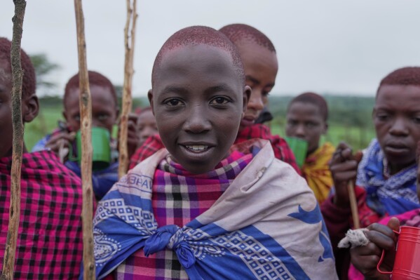 Isaac Mpusia, 16 years old, of the Maasai tribe poses for a photo, during the Enkipaata ceremony, a Maasai male rite of passage, specifically the initiation of boys, marking the transition from childhood to becoming a moran (warrior) in Olaimutiai, Narok County, Kenya Thursday, April 24, 2024. (AP Photo/Brian Inganga)