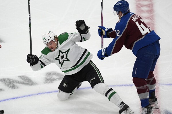 Colorado Avalanche defenseman Josh Manson, right, knocks over Dallas Stars center Roope Hintz, left, in the first period of Game 3 of an NHL hockey Stanley Cup playoff series Saturday, May 11, 2024, in Denver. (AP Photo/David Zalubowski)