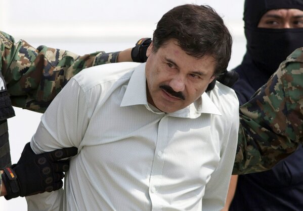 FILE - In this Feb. 22, 2014 file photo, Joaquin "El Chapo" Guzman, the head of Mexico's Sinaloa Cartel, is escorted to a helicopter in Mexico City following his capture in the beach resort town of Mazatlan, Mexico. The Mexican drug kingpin, who was convicted in a New York federal court in February 2019 on multiple conspiracy counts in an epic drug-trafficking case, was sentenced to life behind bars in a U.S. prison. (AP Photo/Eduardo Verdugo, File)