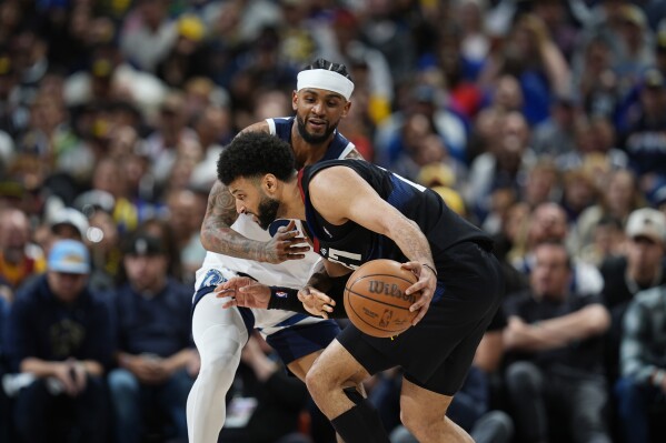 Denver Nuggets guard Jamal Murray, front, looks to drive past Minnesota Timberwolves guard Nickeil Alexander-Walker in the second half of Game 2 of an NBA basketball second-round playoff series, Monday, May 6, 2024, in Denver. (AP Photo/David Zalubowski)