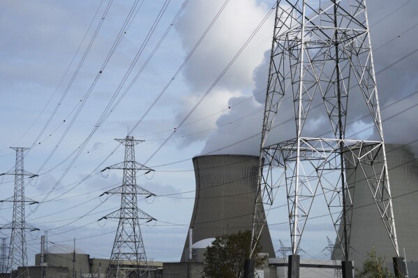 FILE - Steam billows from a nuclear power plant next to utility lines in Doel, Belgium, Oct. 11, 2021. Leaders of European Union countries and other organizations meet for a one day summit on Thursday, March 21, 2024 with the aim of highlighting the role of nuclear energy, reducing the use of fossil fuels, enhancing energy security and boosting economic development. (AP Photo/Virginia Mayo, File)