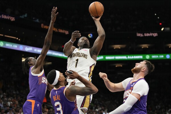New Orleans Pelicans forward Zion Williamson (1) shoots over Phoenix Suns center Bol Bol, guard Bradley Beal (3), and center Jusuf Nurkic (20) during the first half of an NBA basketball game, Sunday, April 7, 2024, in Phoenix. (AP Photo/Rick Scuteri)
