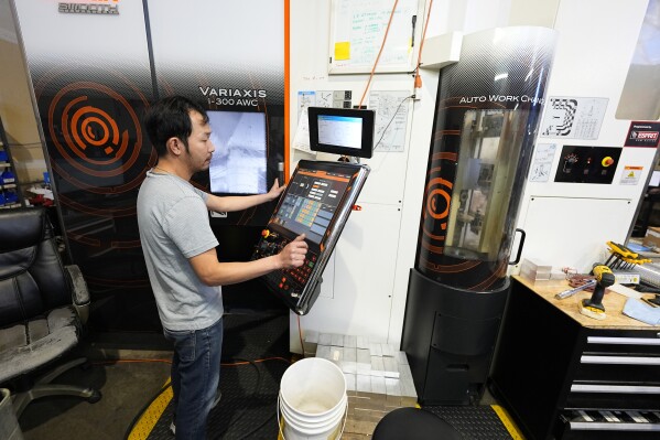 A worker at Reata Engineering and Machine Works programs a Mazak Variaxis machine used to make semiconductor pieces, Thursday, Feb. 15, 2024, in Englewood, Colo. Reata, which supplies the aviation and medical device industries, has invested heavily in software that automates its manufacturing processes. It's also been training workers to use more sophisticated equipment. (AP Photo/David Zalubowski)
