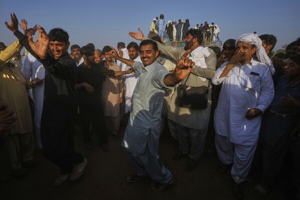 Members of a team dance as they celebrating after winning a traditional bull race competition, in Malal, a village of Attock district, in Pakistan, Thursday, May 15, 2025. (AP Photo/Anjum Naveed)