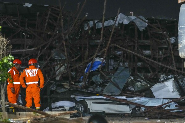 Rescuers look for victims under a billboard that collapsed following heavy rain and thundershowers in Mumbai, India, Monday, May 13, 2024. Scores of people were thought to be trapped after the collapse in the suburb of Ghatkopar, Mumbai police said on social media platform X. (AP Photo/Rafiq Maqbool)