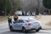 Athens-Clarke County police block traffic and investigate at the UGA intramural Fields after the body of a women was found with found with visible injuries was found in the woods around Lake Herrick in Athens, Ga., on Thursday, Feb. 22, 2024. The brother of the man charged with killing the Georgia nursing student has been accused of presenting a fake green card to police as they investigated the woman's death, according to federal authorities. (Joshua L. Jones/Athens Banner-Herald via AP, File).