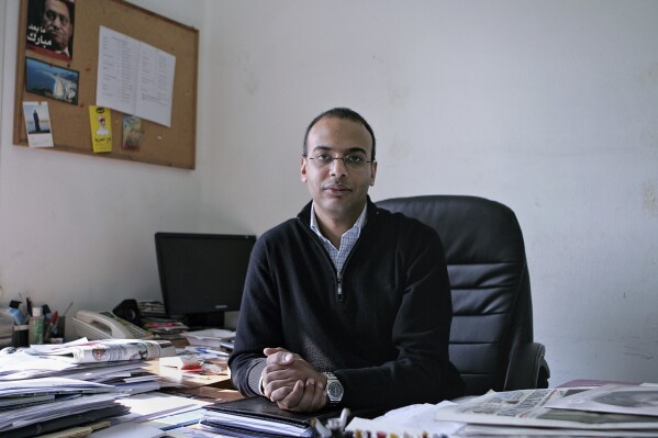 FILE - Hossam Bahgat sits for a photograph, in his office at the Egyptian Initiative for Personal Rights in Cairo, Egypt, Dec. 7, 2011. An Egyptian court has sentenced Hisham Kassem, a fierce government critic, to six months in prison over charges the stemmed from an online spat with a former minister and opposition figure, according to Hossam Bahgat, head of the Egyptian Initiative for Personal Rights which represents Kassem before the court. (Sarah Rafea via AP, File)