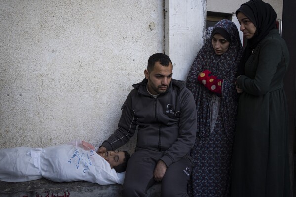 FILE - Palestinians mourn a child killed in the Israeli bombardment of the Gaza Strip at a hospital morgue in Rafah, Monday, Feb. 12, 2024. (AP Photo/Fatima Shbair, File)