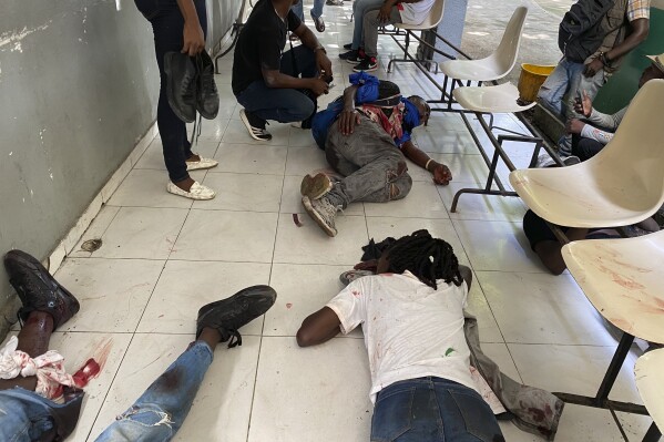 Journalists lie wounded after being shot by armed gangs at the general hospital in Port-au-Prince, Haiti, Tuesday, Dec. 24, 2024. (AP Photo/Dieugo Andre)