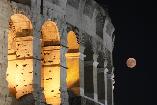 A supermoon rises over the Colosseum in Rome, Wednesday, Aug. 30, 2023. (AP Photo/Gregorio Borgia)
