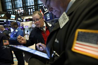 Michael Conlon, center, works with fellow traders on the floor of the New York Stock Exchange, Thursday, March 12, 2020. Stocks are sharply lower after resuming trading as traders fear that not enough is being done to contain the economic damage from the coronavirus pandemic. (AP Photo/Richard Drew)