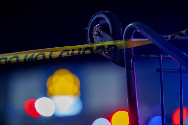 A grocery cart is used to hold caution tape as police work the scene of a shooting at the West Side Walmart in Evansville, Ind., Thursday, Jan. 19, 2023. Authorities in Indiana say a 25-year-old man opened fire in a Walmart store where he once worked, wounding at least one person before officers fatally shot him. (MaCabe Brown /Evansville Courier & Press via AP)