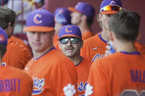 Clemson head coach Erik Bakich talks with players in the dugout between innings during an NCAA baseball game against South Carolina on Sunday, March 5, 2023, in Columbia, S.C. Clemson is coming off its first series win over Miami since 2012, and first in Coral Gables since 2006. The Tigers are 24-3 and off to their best start since 2002. (AP Photo/Sean Rayford)