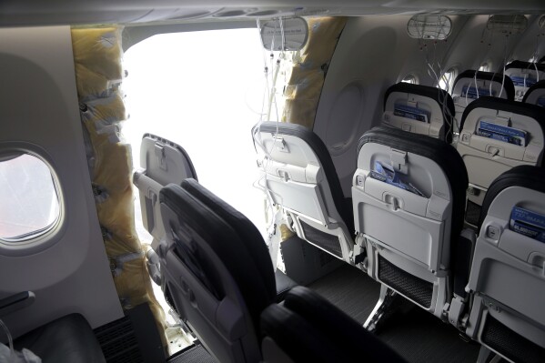 This photo released by the National Transportation Safety Board shows a gaping hole where the paneled-over door had been at the fuselage plug area of Alaska Airlines Flight 1282 on Sunday, Jan. 7, 2024, in Portland, Ore. A panel used to plug an area reserved for an exit door on the Boeing 737 Max 9 jetliner blew out Jan. 5, shortly after the flight took off from Portland, forcing the plane to return to Portland International Airport. (National Transportation Safety Board via AP)