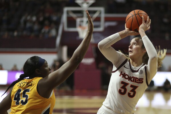 Virginia Tech's Elizabeth Kitley (33) looks to shoot over UNC-Greensboro's Jay'lin Hasting (45) in the first half of an NCAA college basketball game in Blacksburg, Va., Monday, Nov. 20 2023. (Matt Gentry/The Roanoke Times via AP)