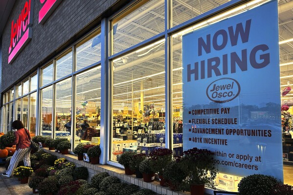 FILE - A hiring sign is displayed at a grocery store, Oct. 5, 2023, in Deerfield, Ill. Most business economists think the U.S. economy could avoid a recession in 2024, even if the job market ends up weakening under the weight of high interest rates, according to a survey released Monday, Dec. 4. (AP Photo/Nam Y. Huh, File)