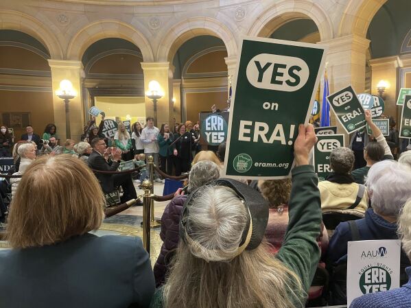 A green sign that says "YES on ERA!" is held by a supporter of the proposed Minnesota Equal Rights Amendment at the Minnesota Capitol building in St. Paul, Minn., Feb. 12, 2024. The proposal would be among the most expansive protections of abortion rights and LGBTQ rights in the nation if it is approved by lawmakers this session and then by Minnesota voters on the 2026 ballot. (AP Photo/Trisha Ahmed)