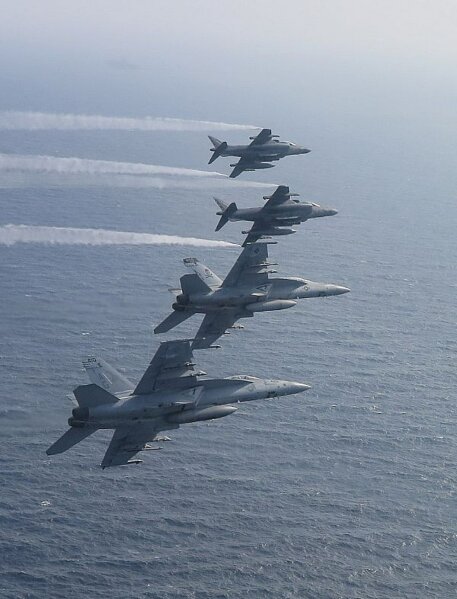 
              In this Saturday May 18, 2019, photo, two U.S. F/A-18E Super Hornets fly alongside two AV-8B Harrier over the Arabian Sea. The Abraham Lincoln Carrier Strike Group and Kearsarge Amphibious Ready Group are conducting joint operations in the U.S. 5th Fleet area of operations, as Mideast tensions remain high between Tehran and the United States. (Lt. Logan Holshey/US Navy via AP)
            