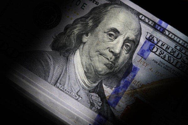 File - La somiglianza di Benjamin Franklin è vista sulle banconote da 100 dollari, giovedì 14 luglio 2022, a Marple Township, Pennsylvania. Con l'aiuto della tecnologia, i truffatori stanno ingannando gli americani con più soldi che mai.  Ma ci sono dei passaggi che puoi adottare per mantenere i tuoi soldi e le tue informazioni al sicuro.  (Foto AP/Matt Slocum, file)