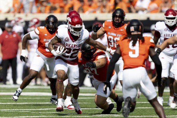 Arkansas running back Ja'Quinden Jackson (22) runs past Oklahoma State nose tackle Justin Kirkland (97) during the first half of an NCAA college football game Saturday, Sept. 7, 2024, in Stillwater, Okla. (AP Photo/Mitch Alcala)