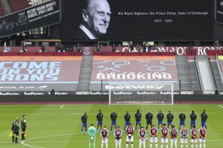 West Ham United and Leicester City players observe a two minute's silence in memory of the Prince Philip, following the announcement of his death at the age of 99, ahead of the English Premier League soccer match between West Ham United and Leicester City at the London Stadium in London, Sunday, April 11, 2021. (Julian Finney/Pool via AP)