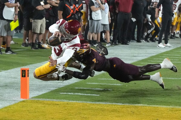 Southern California quarterback Caleb Williams (13) scores a touchdown over Arizona State defensive back Shamari Simmons during the first half of an NCAA college football game, Saturday, Sept. 23, 2023, in Tempe, Ariz. (AP Photo/Rick Scuteri)